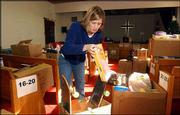 Michelle Levett, a Kansas University graduate student from
Thibodaux, La., boxes holiday gifts for needy families. Levett
worked Friday at the Salvation Army, 946 N.H., one of several
social service agencies in Lawrence that have received community
assistance this year.