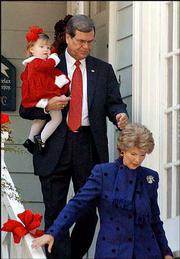 Outgoing Republican Senate leader Trent Lott carries his
granddaughter, Shields Armstrong, as he and his wife, Tricia, leave
their home en route to church services in Pascagoula, Miss. Lott
said Sunday that he had fallen into a "trap" set by his political
enemies.