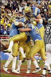 UCLA's Tyler Ebell (2) is mobbed by teammates after he scored a
touchdown during Wednesday's Las Vegas Bowl in Las Vegas.