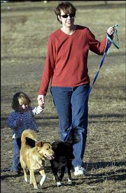 Farrell Jenab walks with her daughter Lucy, 17 months, and their
dogs Marge, left, and Sylvio at the Lawrence Parks and Recreation
"Mutt Run" off-leash dog park east of the Clinton Lake Dam. The
Jenab family joined dozens of other people and their dogs in the
unseasonably warm weather Wednesday afternoon.