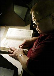 Carol McGee checks out an old directory for the name of an ancestor
who died long ago. She is a volunteer at St. Louis Genealogy
Society in Missouri.