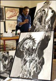 artist and KU architecture professor Hobart Jackson works on a
figure study painting in his Lawrence studio. In the foreground are
three examples of his ink drawings featuring black male models.
Jackson is also a photographer who specializes in architectural
photography.