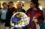 From left, Emily Torres, 14, Erica Demby, 11, Jamica Brouhard, 12,
and Rachelle Moeding, 14, view a Jayhawk Tiffany-style lamp at the
Boys & Girls Club of Lawrence, 1520 Haskell Ave. The Lawrence
St. Patrick's Day Parade Committee announced Wednesday that
proceeds from all the committee events this year will go to the
Boys & Girls Club's after-school program.