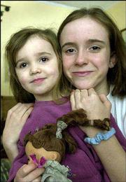 Julianne Cook, 4, left, and her sister, Anna-Lara, 11, embrace at
their Sterling home. The girls were attacked nearly a year ago by a
neighbor's pit bull, which prompted a ban on the dogs in the
central Kansas town.