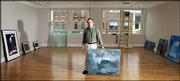 James Schaefer stands next to a painting that&squot;s part of the first
exhibit at the Signs of Life art gallery. Schaefer is director of
the new gallery, which is upstairs from a bookstore and espresso
shop, also part of Signs of Life, at 722 Mass. The first art show,
"Light and Shadow Never Stand Still," features seven landscape
artists.
