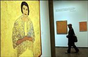 A visitor walks through the Beauford Delaney retrospective exhibit
at the Carpenter Center for the Visual Arts on Harvard University's
campus in Cambridge, Mass. A portrait of singer Marian Anderson,
left, among 29 Delaney paintings on view at the center through May
4, demonstrates the artist's love for the color yellow.