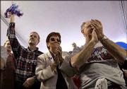 Kansas University fans, from left, Chris Hurding, Wichita, and
Barbara and Lee Curtis, Lenexa, whoop it up at a pep rally at the
VictoryFest in the West End in Dallas. Saturday's KU-Missouri game,
however, was a 68-63 loss for the Jayhawks.