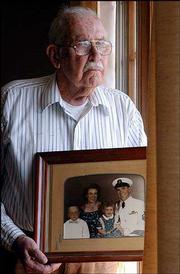 Donald Binns holds a picture of himself in uniform before going off
to World War II. Binns, 85, was captured on Guam and spent most of
the war as a prisoner of war. Also shown in the old photograph are
his wife, Eunice, who passed away seven years ago, his son, Donald
Victor, and daughter, Joanne Eunice.