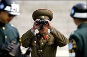A North Korean soldier looks toward the South through a pair of
binoculars, between two South Korean soldiers at the demilitarized
zone in the border village of Panmunjom between the two Koreas.
North Korea on Wednesday cut off the only regular military contact
with the U.S.-led United Nations Command that monitors the Korean
War armistice, accusing the United States of trying to attack the
communist state.