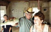 Jim McCrary, center, co-director of the Hobbs Park Memorial, shows
a unique glass bottle to National Park Service representative Sue
Pridemore, right. Pridemore was on a tour of historic sites in
Douglas County as Judy Billings, left, director of the Lawrence
Convention and Visitor's Bureau, looks on.