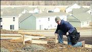 Groene Brothers Construction worker Steve Koester maps out the
location of support beams for a deck on a home near the
intersection of Kasold Drive and Peterson Road.