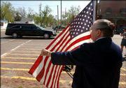 Doris Shelton, a member of the American Legion Auxiliary in
Wellsville, pays respects to the hearse carrying Army Sgt. Jake
Butler to Wellsville Cemetery. The funeral procession traveled
Monday along Main Street.