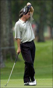 Golfer Fred Couples wipes his face while waiting to putt on the
fifth green. Couples shot a 7-under 65 Thursday at the Houston
Open.