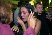 A girl in shock is comforted by a woman at the scene of a suicide
bombing at a beachfront restaurant in Tel Aviv. A huge explosion
early today wrecked a restaurant near the U.S. Embassy. Four
people, including the bomber, were killed in the blast.