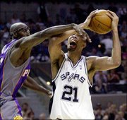 San Antonio's Tim Duncan (21) is fouled by Phoenix's Charles Outlaw
during the first quarter of their Western Conference first-round
game. Duncan scored 23 points and had 17 rebounds in the Spurs'
94-82 win Tuesday night in San Antonio.