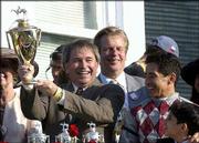 Owner Jackson Knowlton holds up the trophy in the winner's circle
after his horse, Funny Cide, won the Kentucky Derby. Owner David
Mahan, center, and jockey Jose Santos, right, also bask in the
celebration Saturday in Louisville, Ky.