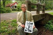 James Grauerholz, longtime companion of William S. Burroughs and
executor of the late author's estate, holds a photo of Burroughs
near a creek that runs near his former home at 1927 Learnard Ave.
Residents of the neighborhood in east Lawrence want the creek to be
named after Burroughs.