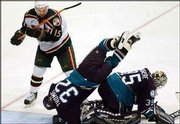 Anaheim's Steve Thomas (32) flies over goalie Jean-Sebastien
Giguere after defending against a scoring attempt by Minnesota's
Andrew Brunette in the third period. The Ducks dumped the Wild, 1-0
in double overtime, Saturday in St. Paul, Minn.