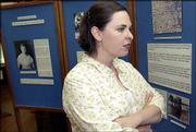 Melissa Arthur, a Kansas University graduate student in the museum
studies program, inspects a new exhibit about Elizabeth Watkins at
the Watkins Community Museum of History, 1047 Mass. Students in the
program's exhibits class researched and mounted the exhibition as
their final project. A photograph of Watkins, who died in 1939, is
visible over Arthur's right shoulder.