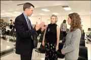 From left, Rep. Paul Davis, D-Lawrence, speaks with Lawrence
teachers Lisa Rush and Bria Klotz. Because of state budget cuts,
neither Rush nor Klotz were offered teaching contracts for next
year. The trio spoke after a news conference Tuesday at Lawrence
High School, where teachers, parents and Davis demanded that
governments reinvest in education.