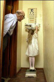 Danielle Irwin, 5, tries on tip-toes to reach the sliding weight on
the old set of scales in Dr. Phil Stevens' Tonganoxie office. The
scales belonged to Stevens' father, Dr. Delos Stevens, and were
used in his Oskaloosa office. Danielle is the daughter of Steve and
Elizabeth Irwin.