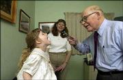 Dr. Phil Stevens, or "Dr. Phil," as many of his patients call him,
checks out the throat of fourth-generation patient Danielle Irwin
as her mother, Elizabeth, watches the proceedings. Stevens has
practiced medicine in Tonganoxie for nearly 50 years.