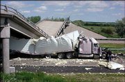 A damaged semitrailer is shown trapped under a collapsed bridge
after a different trailer crashed Friday night into the bridge's
center support columns on Interstate 80 about three miles west of
Big Springs, Neb. Two other eastbound semitrailers also were
damaged. Gov. Mike Johanns said authorities estimated the section
of the nation's busiest highway would reopen Monday, with crews
working round-the-clock.