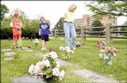 Tyler Kring, 13, left, his brother Connor Kring, 11, and their
mother, Kirsten Price, all of Lawrence, walk through Pioneer
Cemetery on Kansas University's West Campus.