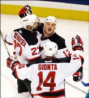 New Jersey's Jeff Friesen, top right, is congratulated by teammates
Scott Niedermayer, left, and Brian Gionta after scoring the Devils'
first goal. New Jersey defeated Anaheim, 3-0, Tuesday night in East
Rutherford, N.J.