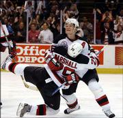 New Jersey's Patrik Elias tackles teammate Grant Marshall as they
celebrate Marshall's third-period goal. The Devils defeated Anaheim
in Game 1 of the Stanley Cup finals, 3-0, Tuesday in East
Rutherford, N.J.