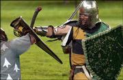 Attila Karolyi, of Kansas City, Kan., battles an opponent at South
Park. Members of the Society for Creative Anachronism -- who dress
and fight in Middle Age form -- gathered Tuesday to stage combat
scenes in the park.