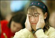 JJ Goldstein, 13, of Great Neck, N.Y., rubs her temples while
taking the written test during the second round of the 76th annual
National Spelling Bee in Washington. The finals of the bee will be
televised today.