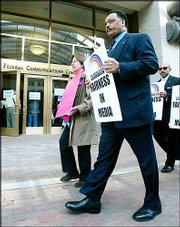 The Rev. Jesse Jackson and Pat O'Leary, of the national peace group
Code Pink, take part in a demonstration outside the Federal
Communications Commission in Washington, D.C. Federal regulators
voted Monday to relax decades-old rules restricting media
ownership, permitting companies to buy more television stations and
own a newspaper and a broadcast outlet in the same city.