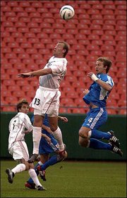 MetroStars' Clint Mathis, center, puts a head on the ball in front
of Kansas City's Carey Talley. The Wizards won, 2-1, Saturday in
Kansas City, Mo.