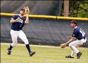 Raiders outfielder Derek Bailey, left, makes a catch as he is
backed up by David Arndt. The Raiders swept an American Legion
baseball doubleheader with Emporia, 11-0 and 6-5, Saturday at Free
State High.