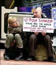 Pamara True, left, joins Peter Schoeff on a downtown sidewalk in
Portland, Ore. In what advertising industry watchers said is a
first, a Portland pizza company, Pizza Schmizza, has hired homeless
people to take part in a marketing campaign. They are paid in
pizza, soda and a few dollars.