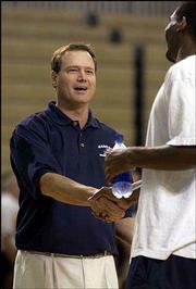 Kansas University basketball coach Bill Self, left, shakes hands
with KU guard Keith Langford. Self's players played a pick-up game
at his camp Wednesday.