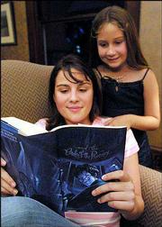 Kaitlin Webster, 14, reads her copy of "Harry Potter and the Order
of the Phoenix" in Daytona Beach, Fla. Her sister, Hailey, 8, back,
found the book Wednesday at a Walgreens drugstore in Daytona Beach,
although the book&squot;s official release is set for 12:01 a.m.
Saturday. The store has since taken remaining copies of the book
off its shelves.