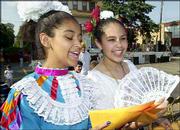 Samantha Romero, 13, left, and Ashley Anguiano, 14, both of
Lawrence, fan themselves as they pass out fliers for the dancing
programs at the 22nd Annual St. John's Fiesta Mexicana. The two-day
fiesta ended Saturday.