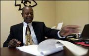 J.R. Demby, loan originator and manager for North American Savings
Bank, looks over loan documents at the company's new Lawrence
location at 1201 Wakarusa Drive. North American Savings Bank is one
of three financial institutions that either have expanded or soon
plan to expand in Lawrence.