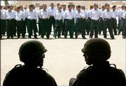 U.S. Army officers attend a ceremony where Iraqi police officers
received new uniforms and used revolvers as part of an American
plan to upgrade the local police force in Fallujah, Iraq. The
police were given a partial order of U.S. Air Force uniforms, as
the local tailor had not finished the order in time for Monday's
ceremony.