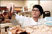 Alison Olewnik transfers cookies onto a pan. Olewnik, a pastry chef
and baker at Community Mercantile Co-op, learned the chemistry of
baking at the Manhattan-based American Institute of Baking.