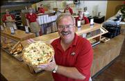 Ken Humm, operator of the new Pizza Pro restaurant at 1800 E. 23rd
St., believes its nontraditional menu items, like this chicken
alfredo pie, will help it stand out among competitors. The pizza
place is just one of several new restaurants opening in Lawrence.