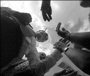 Bob Dole holds a pen in his mouth as he takes a break from signing
autographs for supporters to shake their hands at the end of a
Dole-Kemp rally in 1996 in Pittsburgh. Colleagues and former
opponents call Dole a tireless campaigner.