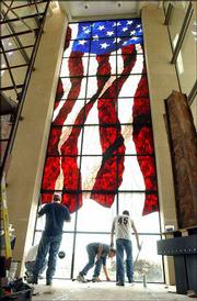 Workers with Stained Glass Overlay, of Roseville, Minn., complete a
stained-glass American flag at the Dole Institute of Politics. The
flag is thought to be the largest stained-glass Old Glory in the
world.