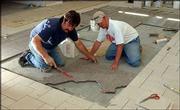 Floorers John Roth and Jonathan Roth, of St. Marys, set some
150-pound pieces of Carnelian granite, from Cold Spring, Minn., at
the Dole Institute. The two Fox Ceramic Tile employees were working
on a tile floor that will have a map of Kansas in it.