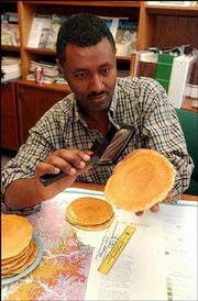 Girmai Misgna, an analyst for the Kansas Geological Survey on
Kansas University's west campus looks over some pancakes Friday, to
see if they resemble Kansas in any way. A team of researchers from
Texas and Arizona recently reported that Kansas was as flat as a
pancake.