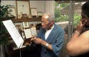 Robert McFerrin, points to sheet music during a music therapy
session in his Creve Coeur, Mo., home. At the piano is Jack
Jenkins, and McFerrin's wife, Athena McFerrin, listens at right.
McFerrin, the father of jazz singer Bobby McFerrin, was the first
black man to be signed by the Metropolitan Opera in New York. He
suffered a stroke in the late 1980s that impaired his ability to
verbalize his thoughts, but he still can sing.