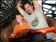 Aaron Girard, 7, left, and his father, Mike Girard, of Wichita,
ride the WildCat roller coaster at Celebration City theme park in
Branson, Mo. The wooden coaster features an 80-foot drop.