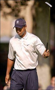 Tiger Woods raises his putter after making an eagle putt during the
second round of the Buick Open. Woods, who finished second last
weekend in Grand Blanc, Mich., might have to win the PGA
Championship in order to snag the PGA Tour player of the year
award.